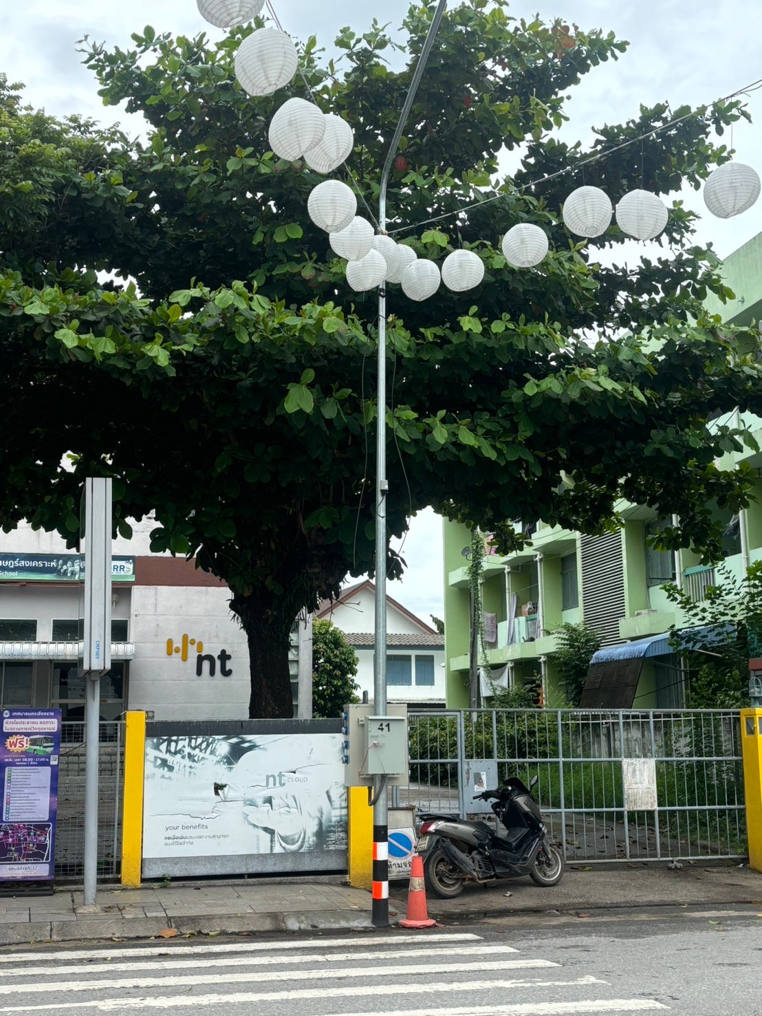 Street-side pole installation beneath decorative lanterns in Chiang Rai, Thailand.
